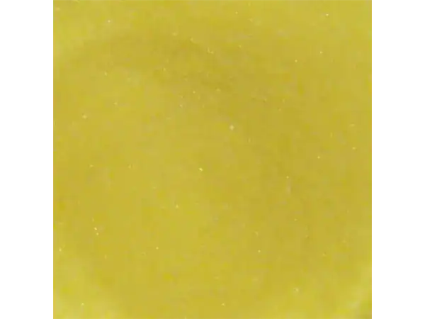 Close-up of Roch Sweets yellow candy surface with sparkling texture.