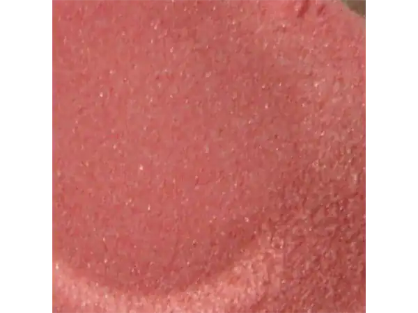 Close-up of soft pink taffy candy with a shiny, textured surface.