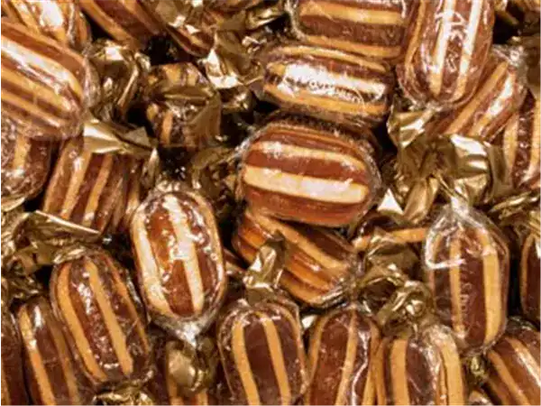 Delicious caramel square candies wrapped in gold foil, perfect for sweet tooth cravings.