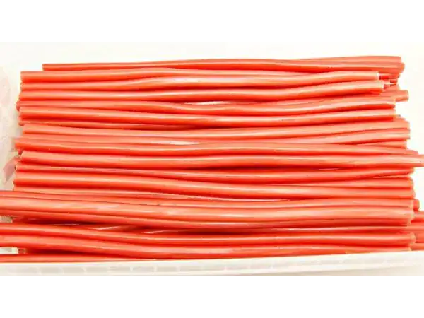 Colorful tarragon licorice candy sticks on white plate, perfect for treats and snacking.