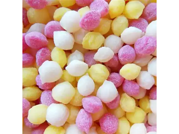 Colorful mini fruit candies with pastel pink, yellow, and white hues. Perfect for kids' treats or party favors.