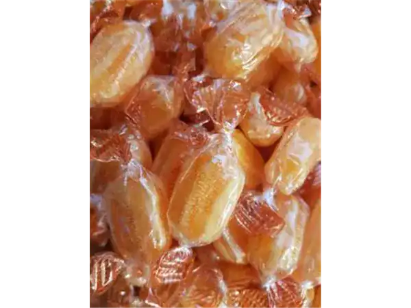 Delicious caramel candies wrapped in clear orange-tinted packaging. Perfect for snacking and gifting.