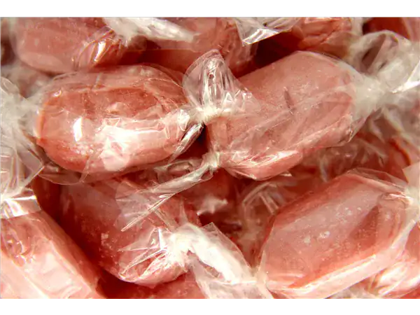 Colorful caramel candies individually wrapped in clear plastic.