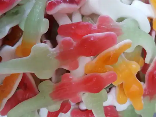 Vibrant gummy worms in red, green, orange, and white, perfect for sour candy lovers.