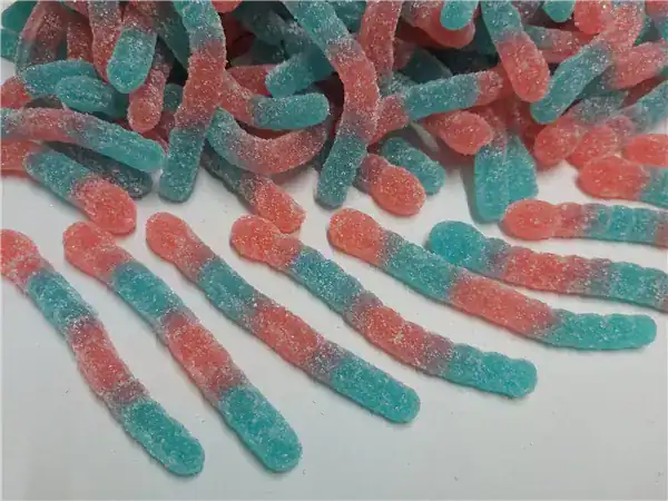 Colorful sour gummy worms in red and blue coated with sugar for a sweet treat.