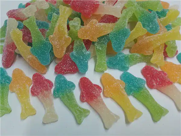 Colorful gummy fish candies covered in sugar crystals, perfect for snacking or party favors.